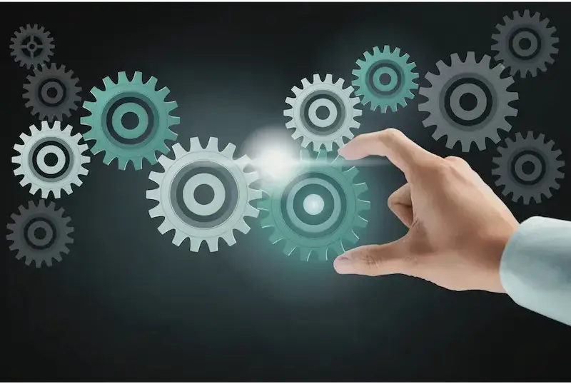 A hand interacting with interlocking gears against a dark background.